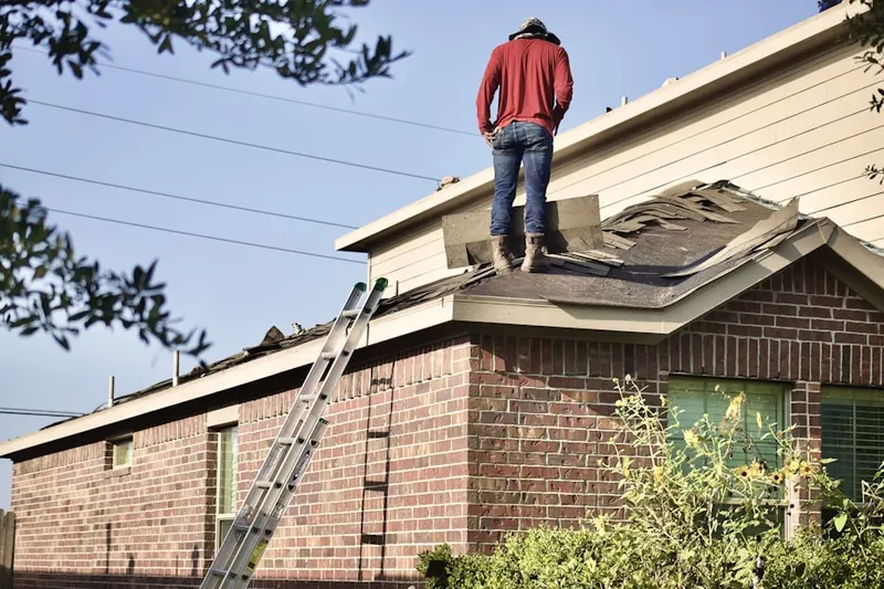 Professional roofer working on a residential roof in Algona
